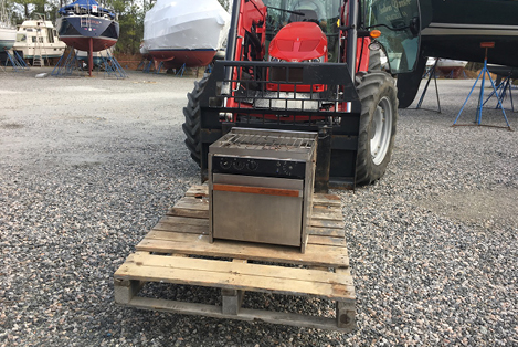 The old oven gets lifted out of the boat
