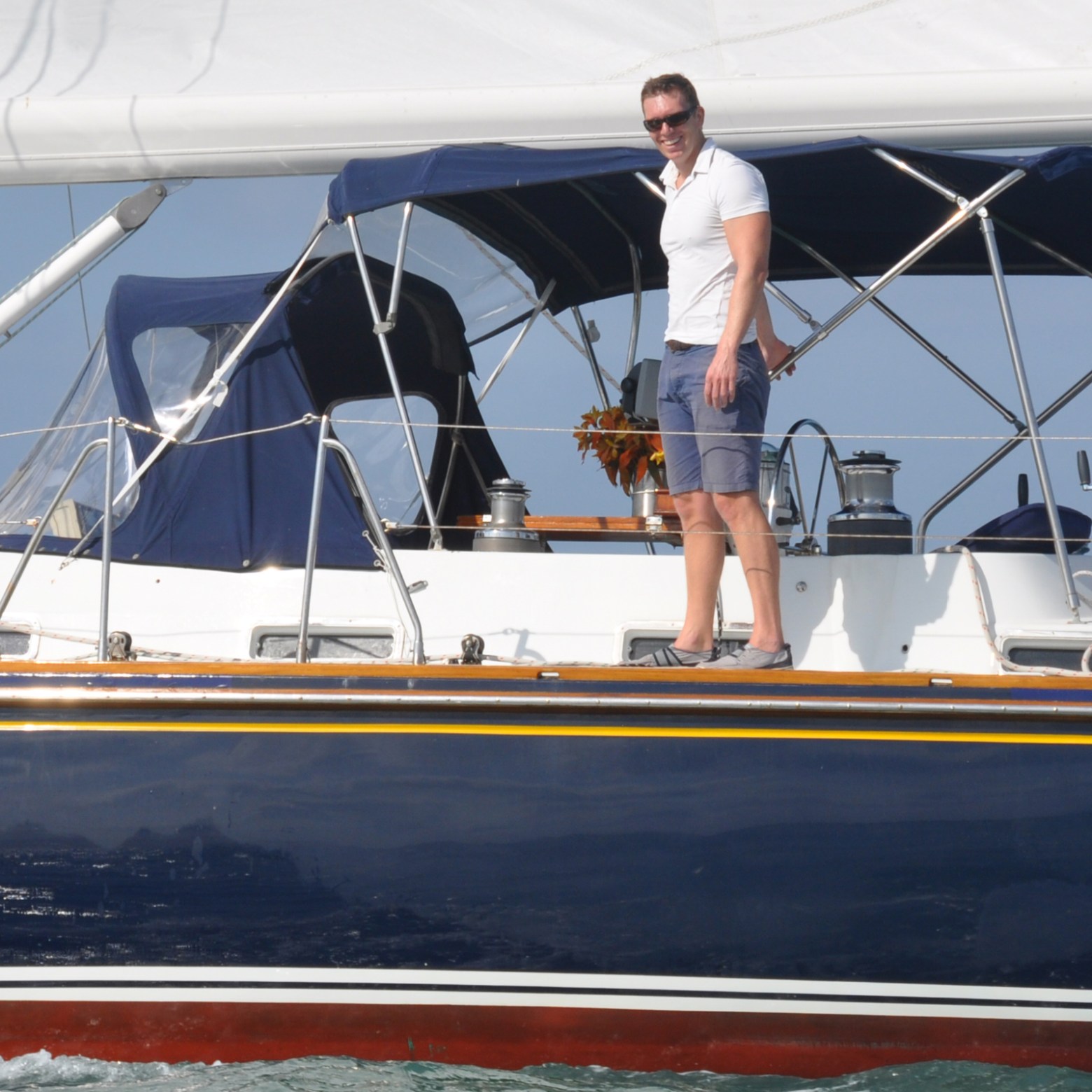 Captain Chris standing on edge of sailboat