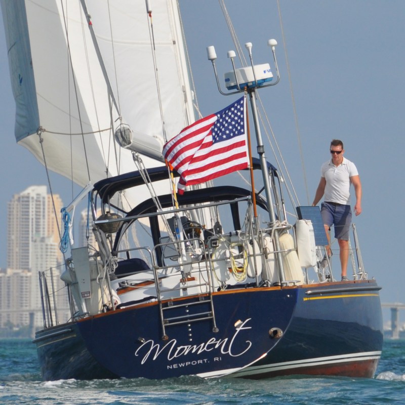 Captain Chris standing on stern of Moment Sailboat
