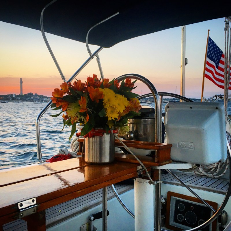 Flowers set up decoratively near steering wheel of Moment sailboat