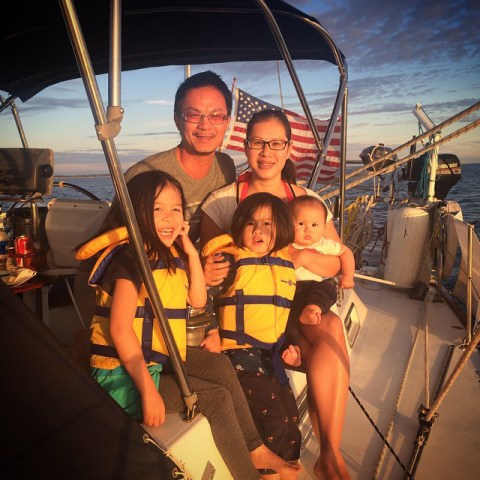 Family photo of family sitting together on sailboat