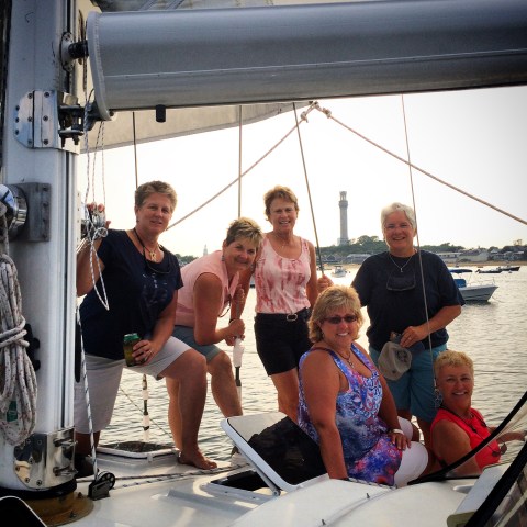 Sailing group of friends posed near back of sailboat for photo